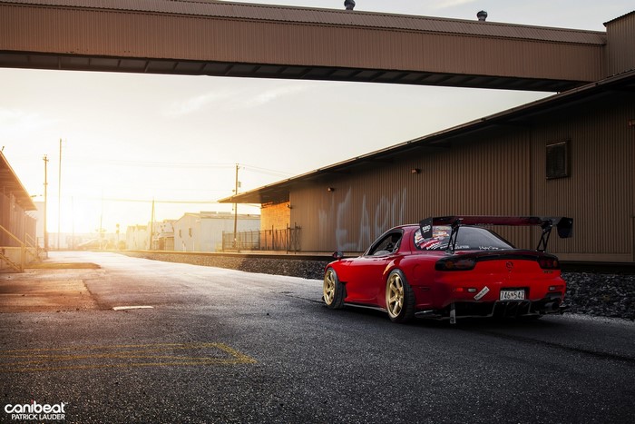 Red Mazda RX-7 FD with large spoiler on road