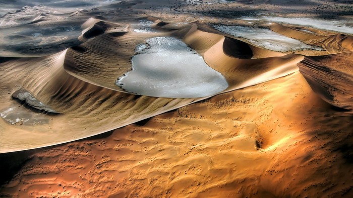 Aerial view of desert dunes with water in Namibia