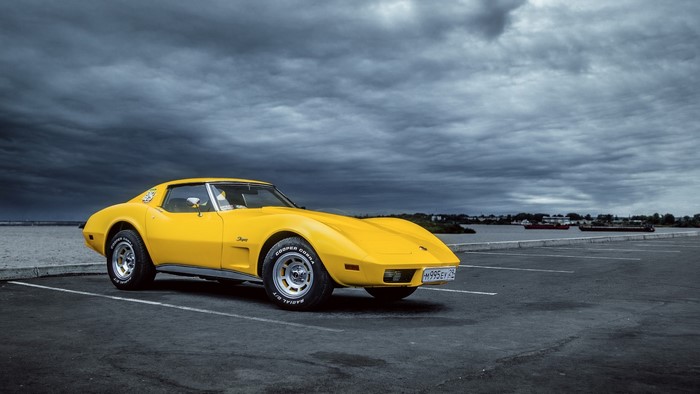Yellow Chevrolet Corvette C3 parked by the water