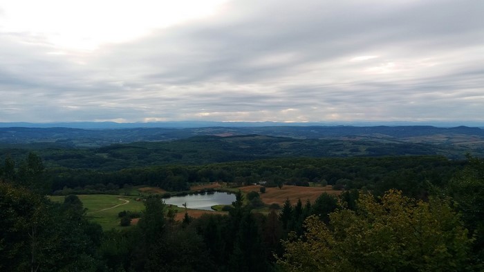 Overcast landscape with rolling hills and a lake