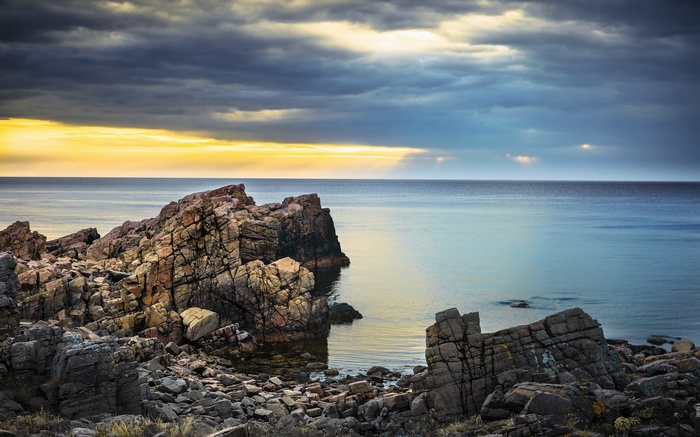 Rocky coastline with dramatic clouds over the sea