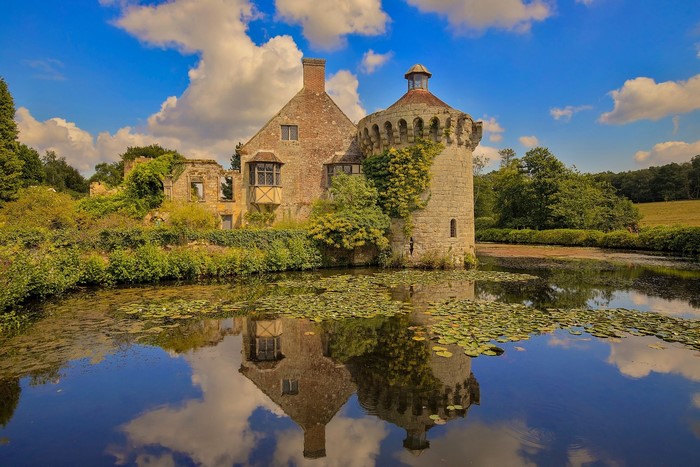 Castle ruins reflected in a pond in England