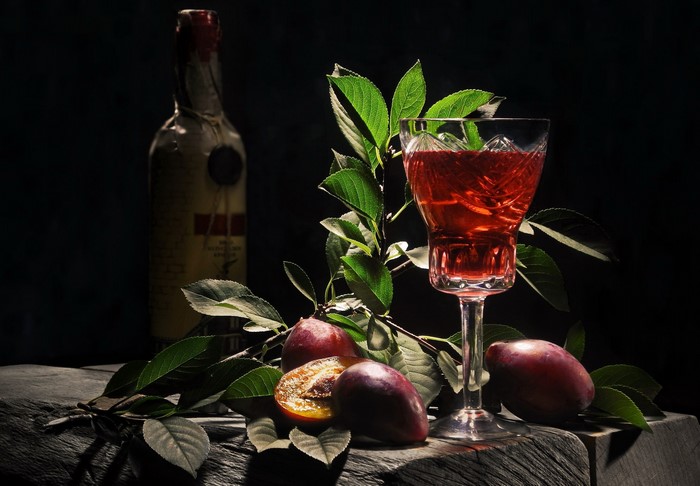 Still life with plums, wine, and bottle