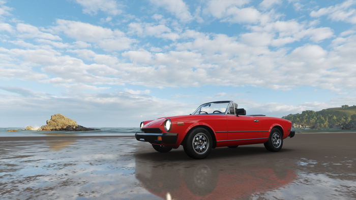 Red convertible car on a beach
