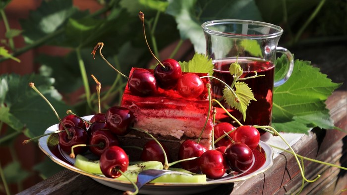 Slice of cherry cake with fresh cherries and juice