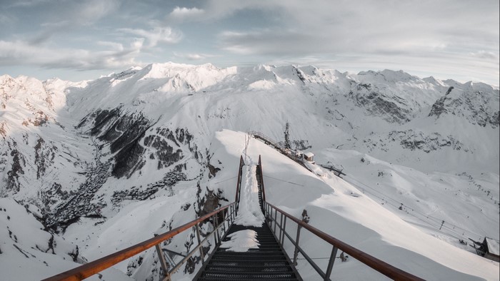 Snowy mountain range with a ski lift and village
