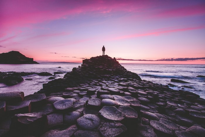 Person standing on Giant's Causeway at sunset