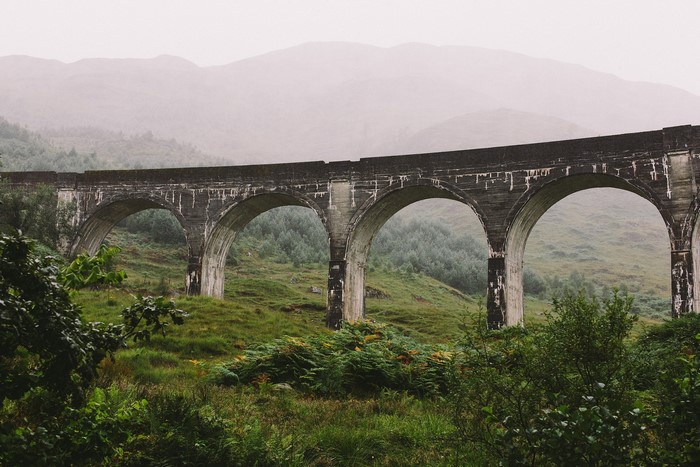Stone viaduct bridge in a misty landscape