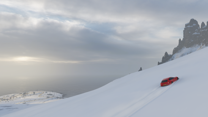 Red Ferrari driving on a snowy mountain in Forza Horizon 4