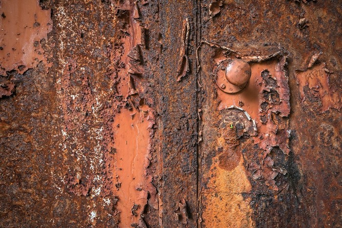 Close-up of heavily rusted metal with peeling paint