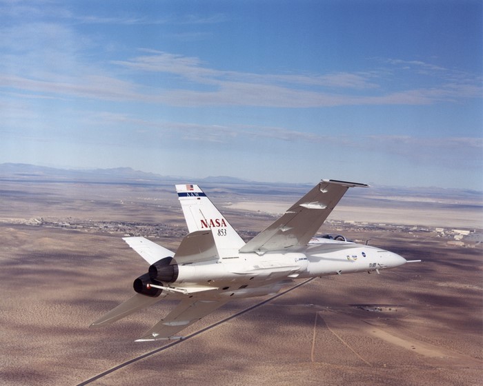 NASA F-18 Hornet aircraft flying over desert landscape