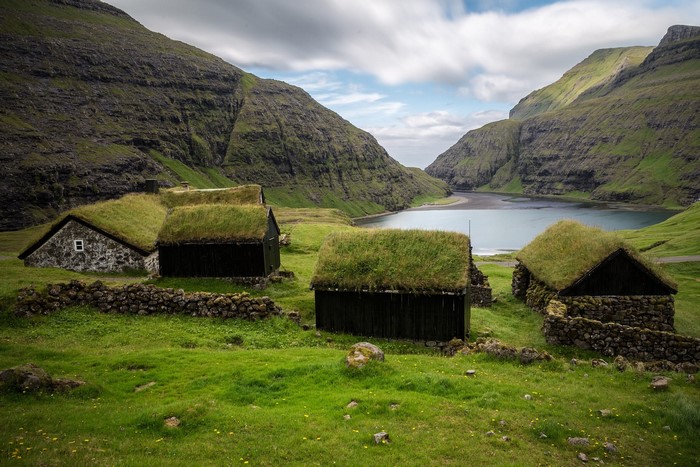 Traditional grass-roofed houses in a valley by a lake