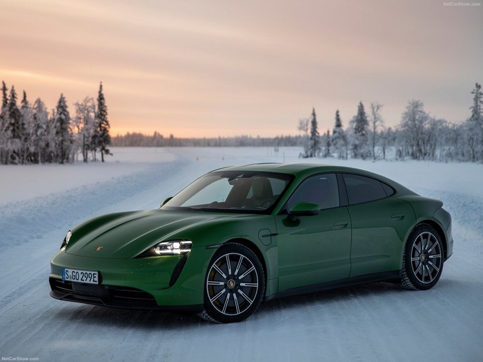 Green Porsche Taycan driving on a snowy road