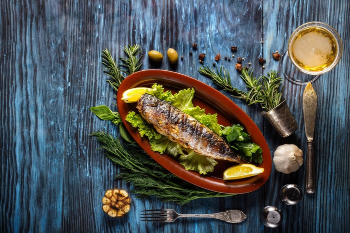 Roasted fish with lemon and herbs on a platter