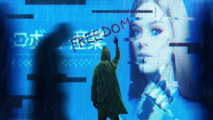 Person in raincoat writing freedom on blue screen