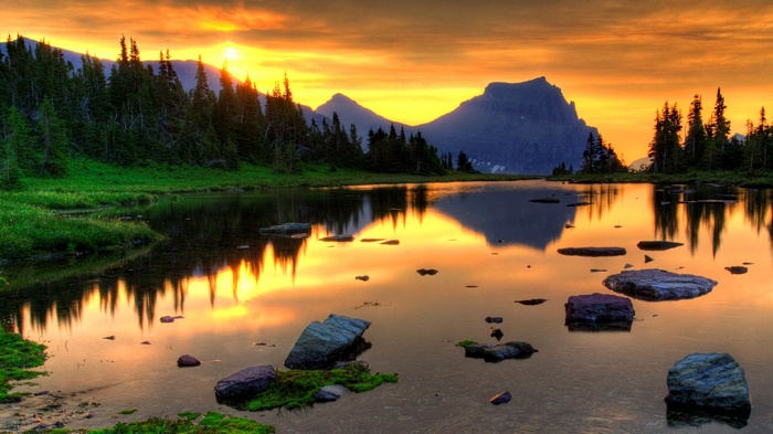 Sunset over a mountain lake with pine trees
