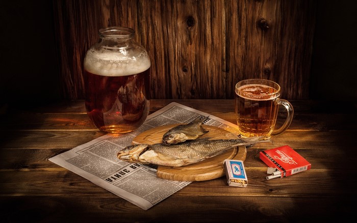 Still life with beer, dried fish, cigarettes, and newspaper