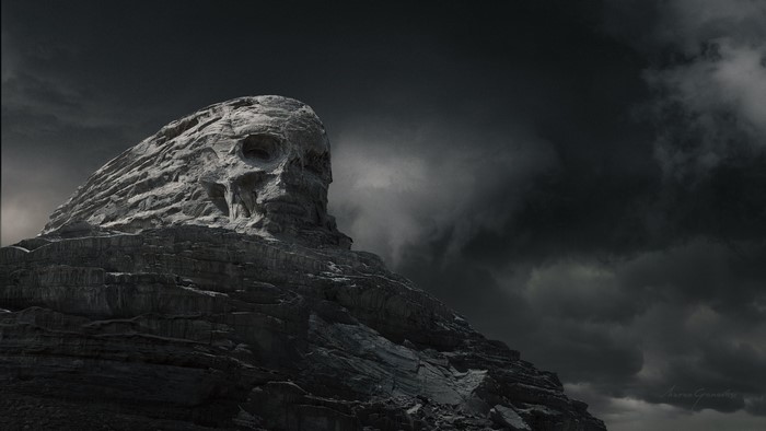 Mountain shaped like a skull under dark clouds