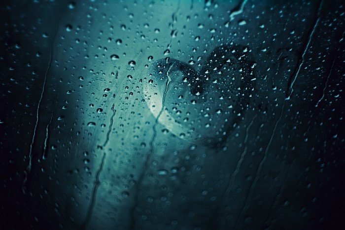 Water drops on glass with a heart shape