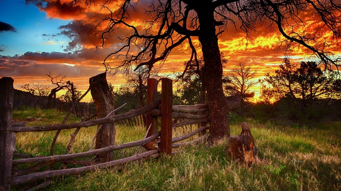 Rustic wooden fence at sunset with dramatic sky
