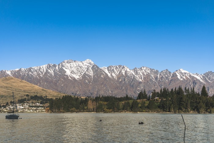 Snow-capped mountains over a lake in Queenstown, New Zealand