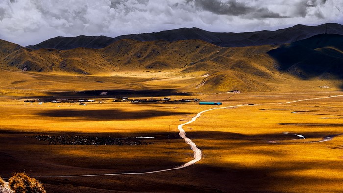 Golden valley with mountains and a winding road