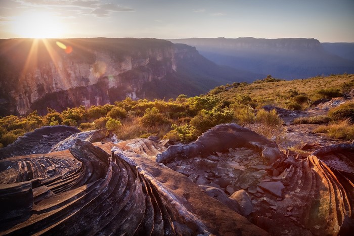 Sunlight over a rocky mountain landscape at sunset