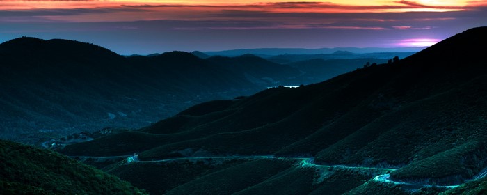 Winding road through mountains at sunset