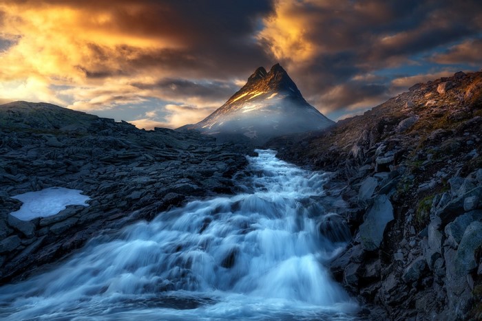 Mountain stream flowing towards a peak in Norway