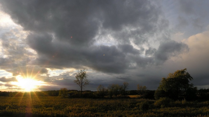 Sunset over a field with dramatic clouds