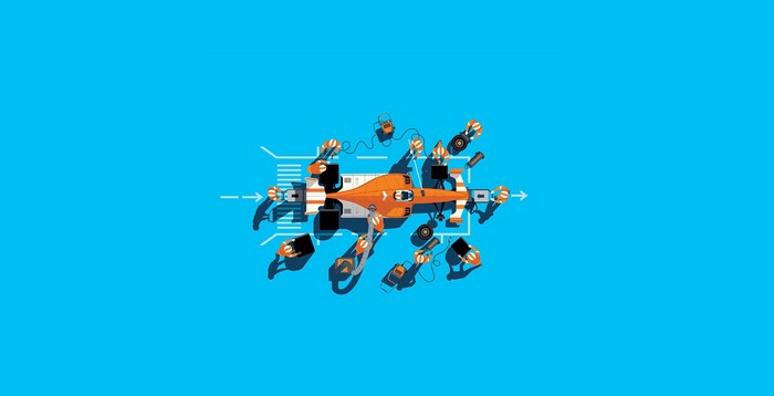 Formula 1 pit stop with orange race car and crew