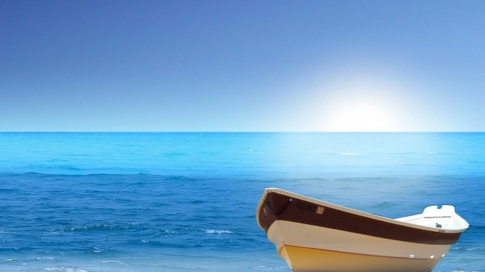 A small boat on the shore of the ocean