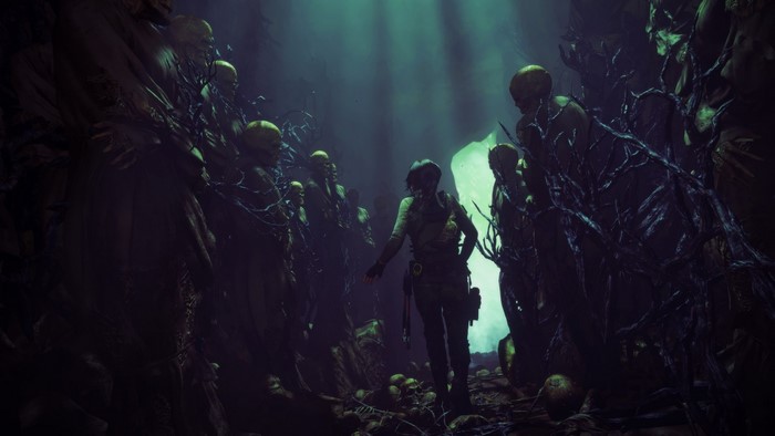 Lara Croft in a dark cave with skulls
