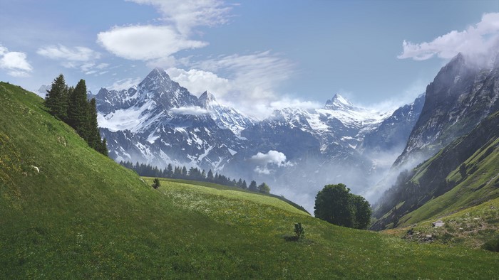 Snow-capped mountains and green hills landscape