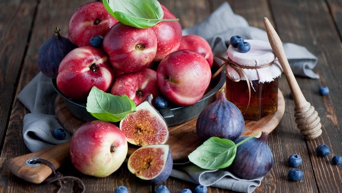 Still life of fruits and honey with a honey dipper