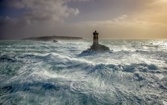 Lighthouse in rough seas with stormy skies