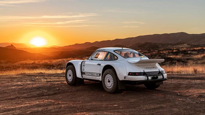 White Porsche 911 rally car in desert at sunset