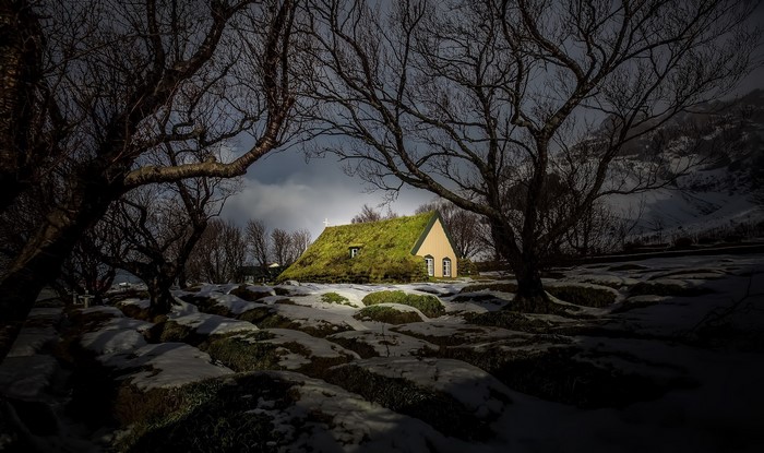 Church with grass roof in winter landscape