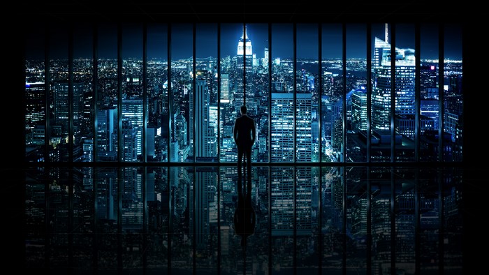 Man standing in front of a city skyline at night