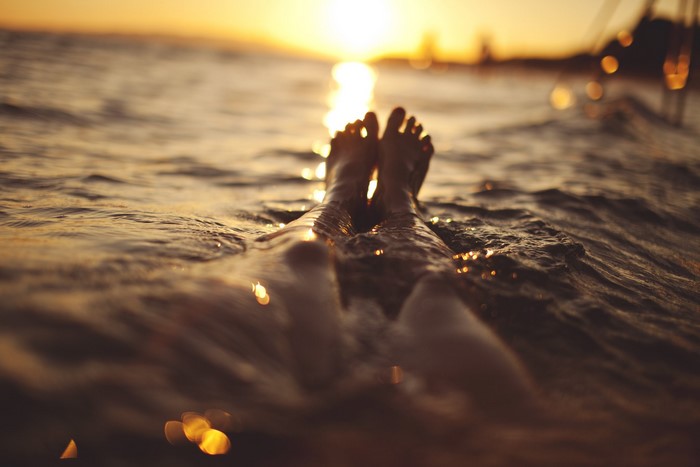 Feet in the water at sunset