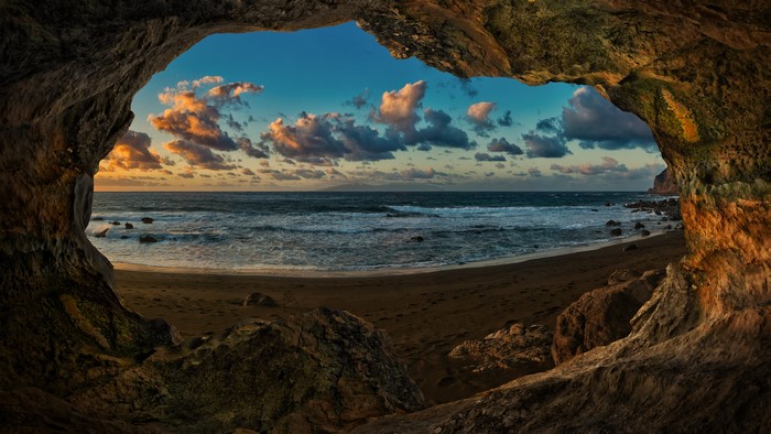 Cave view of Canary Islands coast at sunset