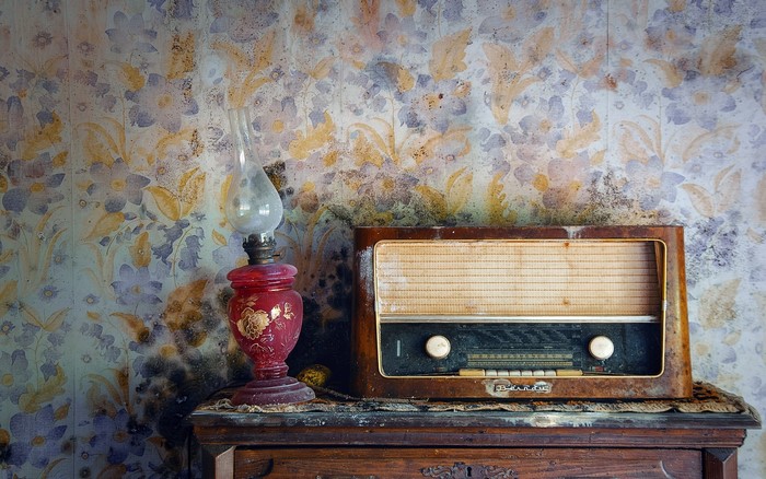Old radio and oil lamp on a dresser