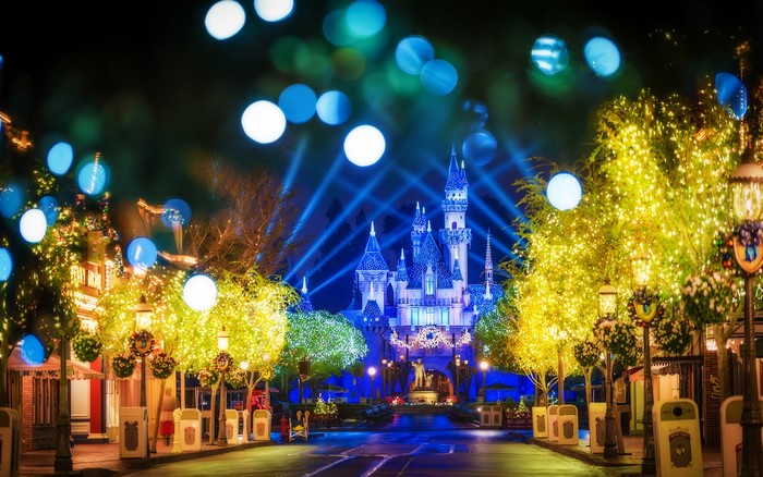 Disneyland castle decorated with Christmas lights at night