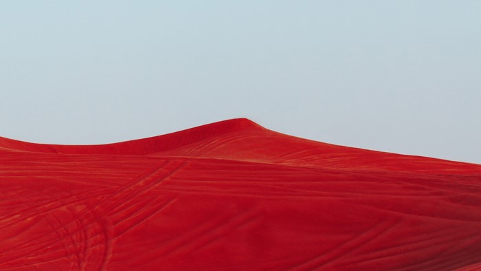 Red desert landscape with tire tracks