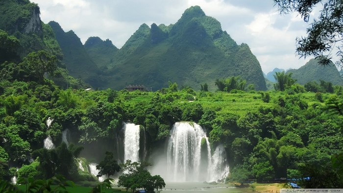 Green mountains and a wide waterfall in a tropical landscape