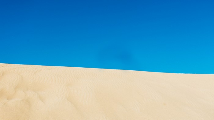 Sand dunes under a clear blue sky
