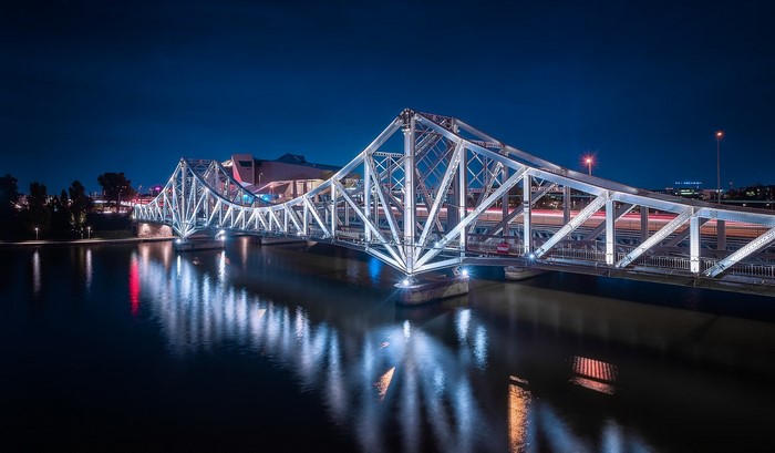 Illuminated bridge over a river at night