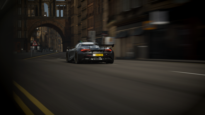 McLaren 720S driving through a city street