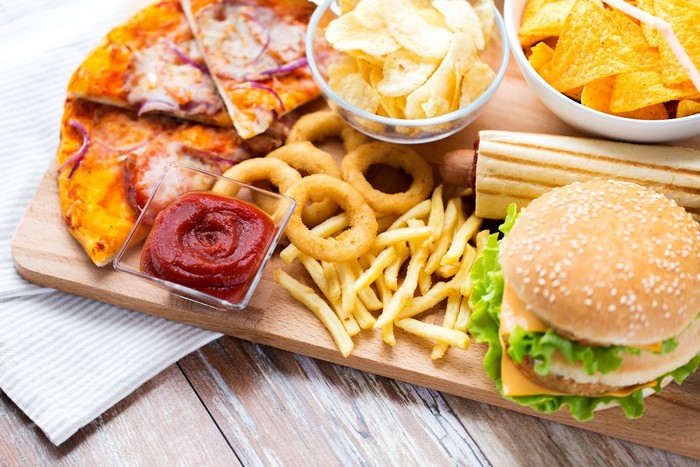 Fast food platter with pizza, burger, fries, and onion rings