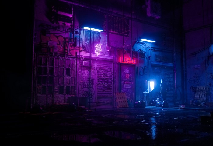 Neon-lit alleyway with graffiti and a lone figure